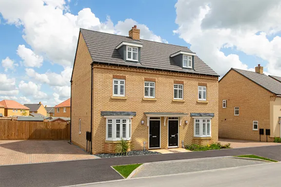 A two-story brick house with a black door and windows.
