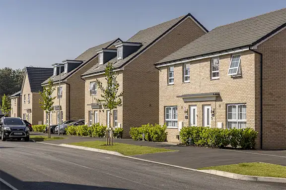 A row of houses with cars parked in front.