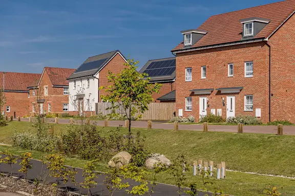 A white house with a grey car parked in front.