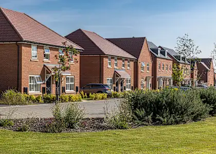 A row of houses with a car parked in the driveway.