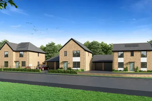 A row of houses with a car parked in front of the first one.